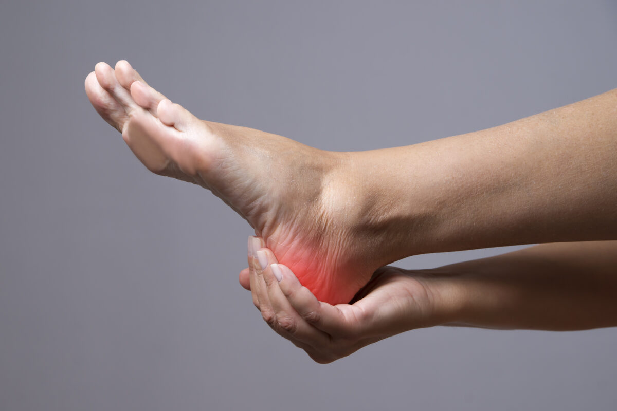 Heel Pain with female holding the heel of the foot.